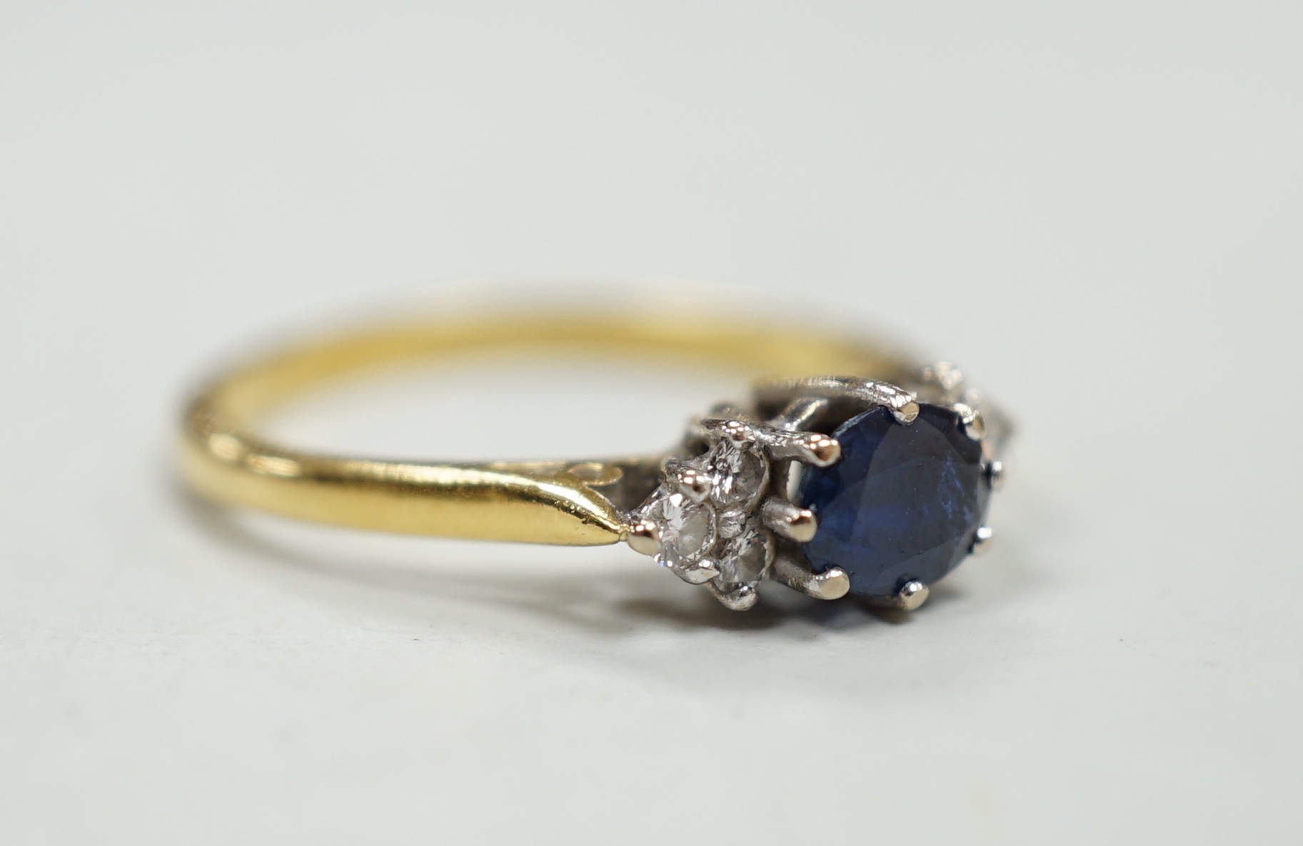 A modern 18ct gold, single stone sapphire and six stone diamond chip set ring, size O/P, gross weight 3.1 grams.